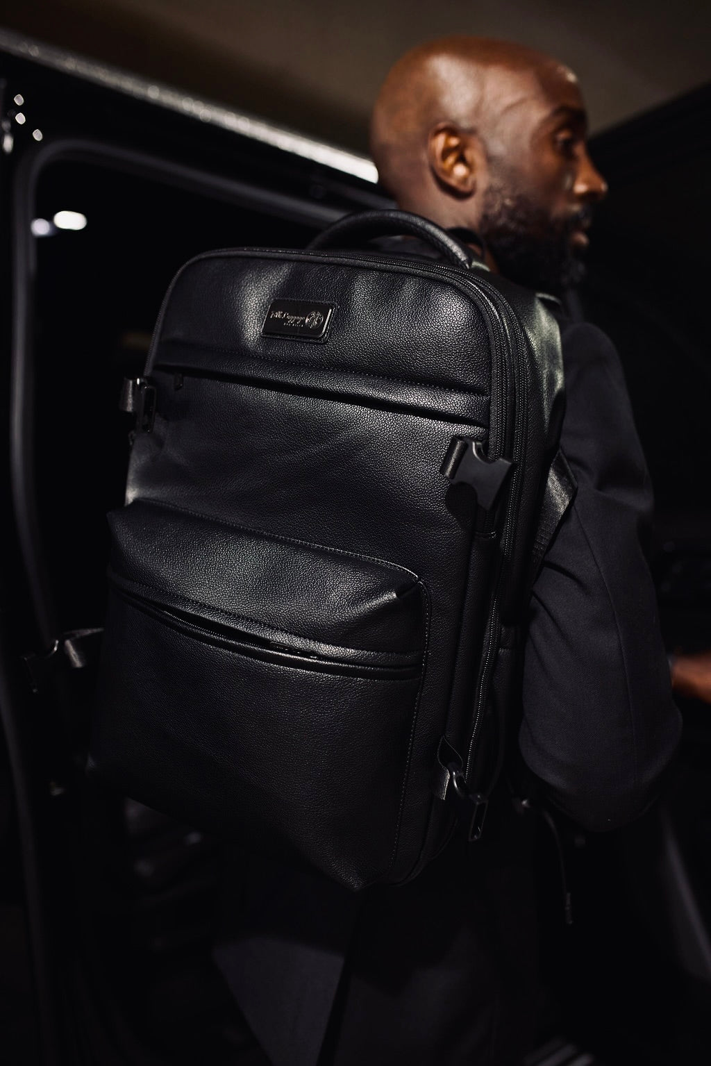 Man wearing BLK Luggage Overnight backpack — premium vegan leather travel backpack